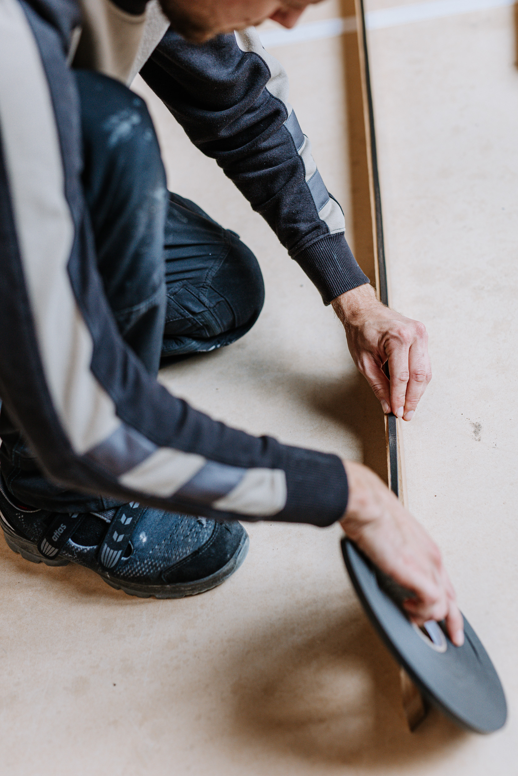 Ein Mitarbeiter misst ein Brett aus.